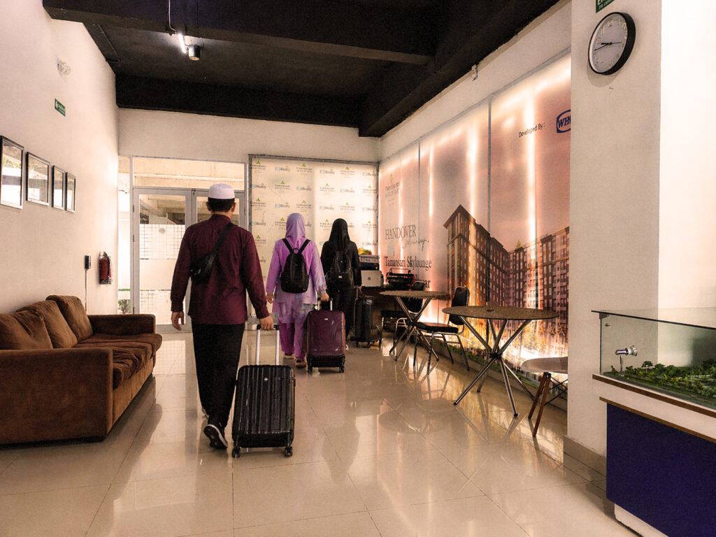 Rombongan jamaah Umroh membawa koper berjalan di lobi Apartemen Tamansari Skylounge Makassar menuju Bandara Sultan Hasanuddin.