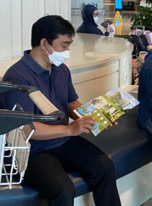 Pengunjung pameran membaca brosur promo apartemen Tamansari Skylounge Makassar di bandara